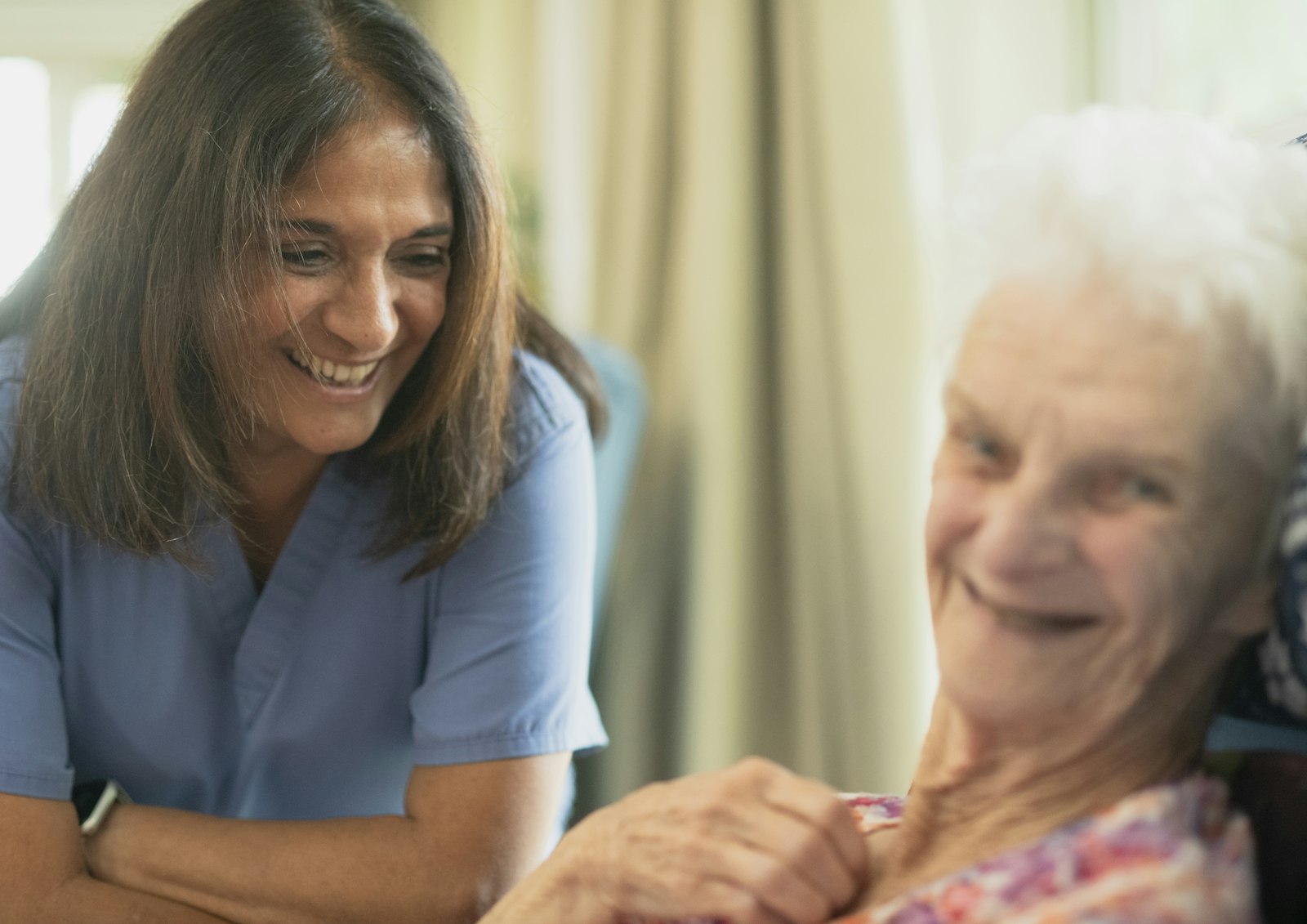 Provider sitting with an elderly patient in a warm room